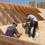 Workers putting down roof sheathing. Tarpaper and shingles go over this. Picture from this website.